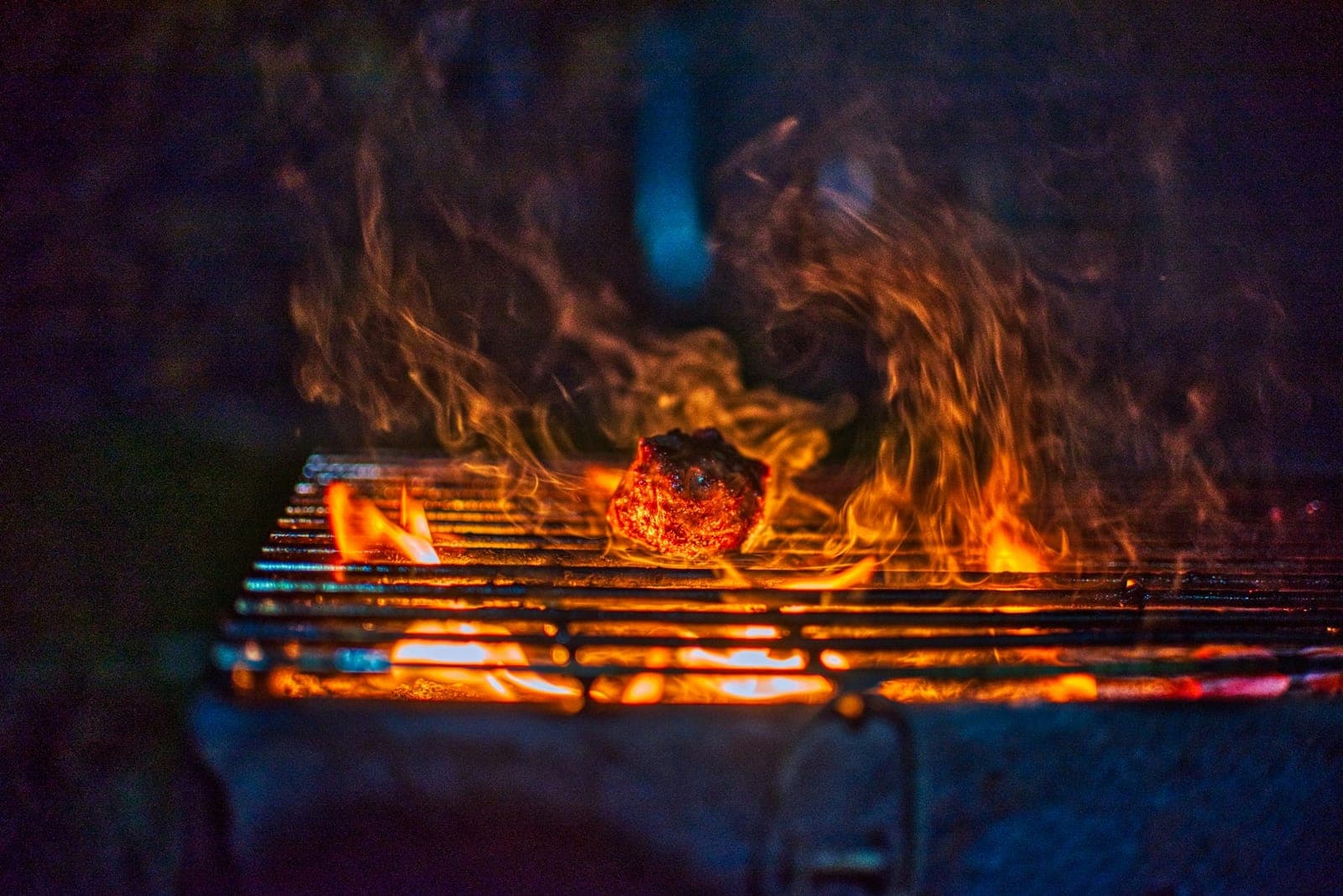 Charcoal fire burning under the grate of a kettle grill