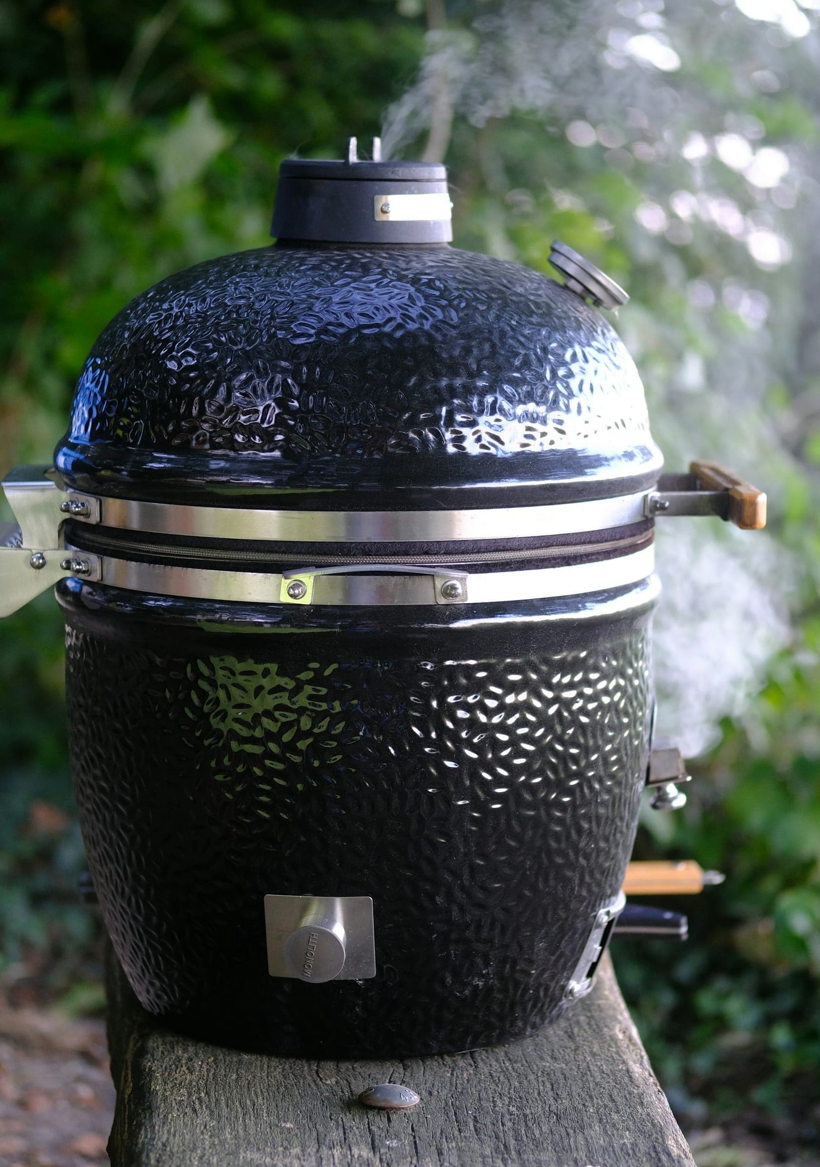 Ceramic kamado grill with the lid closed and smoke rising